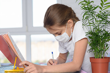 Image showing A sick girl teaches homework and does homework