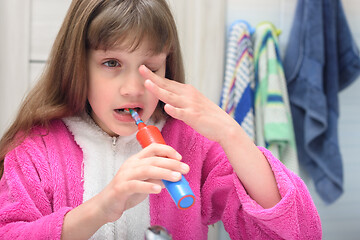 Image showing Sleepy girl brushes her teeth in the early morning