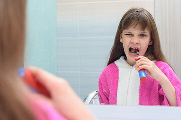 Image showing The girl from toothache decided to brush her teeth