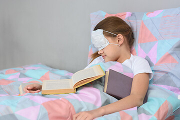 Image showing The sick girl fell asleep lying in bed and pulled the mask over her face