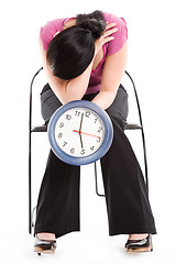 Image showing Tired businesswoman holding a clock
