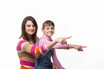 Image showing Mom and girl point a finger to an empty place