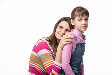 Image showing Happy mother put her head on her daughters back, isolated on white background
