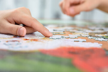 Image showing Close-up of children\'s hands collecting jigsaw puzzles