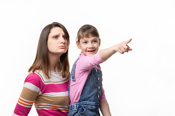 Image showing Happy girl shows something to mom with finger, isolated on white background