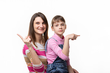 Image showing The girl joyfully points a finger in one direction, the girl is sad in the other