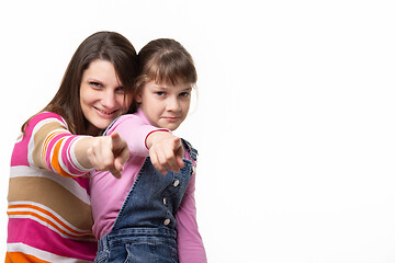 Image showing Mom and daughter point a finger at the frame, side empty space in the frame