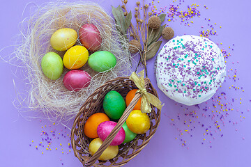 Image showing multi-colored Easter eggs in a basket and nest view from above