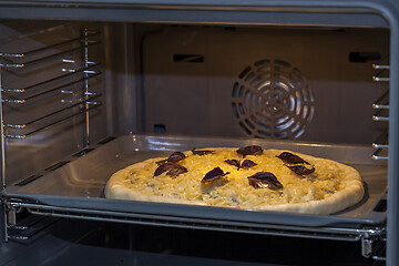 Image showing Baking quattro formaggi pizza in oven with open door.
