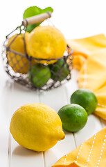 Image showing Organic lemons and limes in a basket on white background