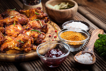 Image showing Hot chicken wings with different spices and dips