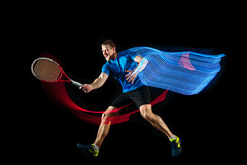 Image showing one caucasian man playing tennis player on black background