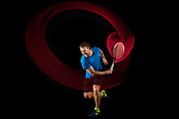 Image showing one caucasian man playing tennis player on black background