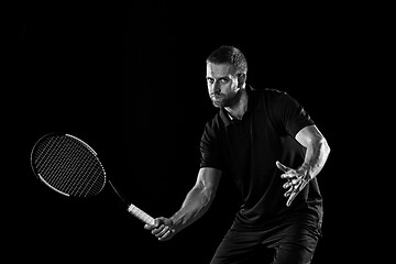 Image showing one caucasian man playing tennis player on black background