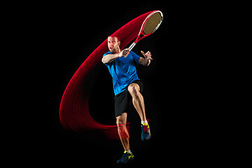 Image showing one caucasian man playing tennis player on black background