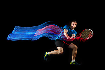 Image showing one caucasian man playing tennis player on black background