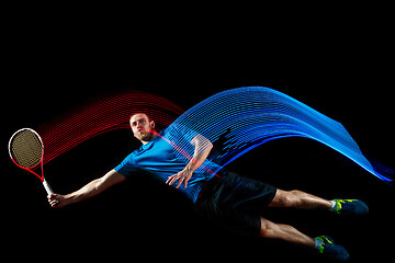 Image showing one caucasian man playing tennis player on black background