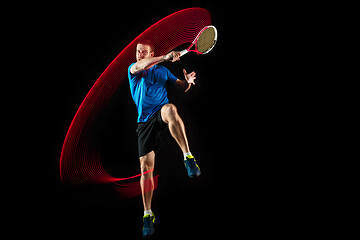 Image showing one caucasian man playing tennis player on black background