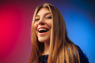 Image showing The happy woman standing and smiling against colored background.