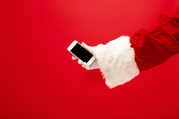 Image showing Santa Claus holding mobile smartphone ready for Christmas time