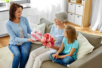 Image showing family giving present and flowers to grandmother