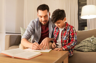 Image showing father and son doing homework together