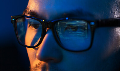 Image showing close up of hacker in glasses looking at screen