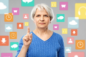 Image showing senior woman pointing finger up over app icons