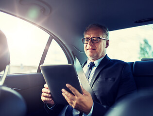 Image showing senior businessman with tablet pc driving in car