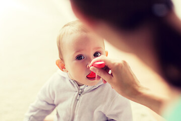 Image showing mother with spoon feeding little baby at home