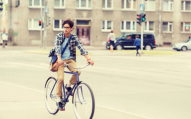 Image showing young hipster man with bag riding fixed gear bike