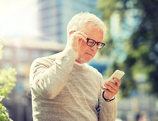 Image showing senior man texting message on smartphone in city