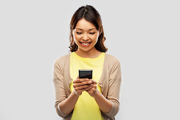 Image showing happy asian woman using smartphone