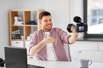 Image showing male blogger with camera videoblogging at office