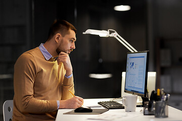 Image showing man with notepad working at night office