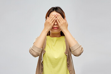 Image showing young woman with eyes closed by hands