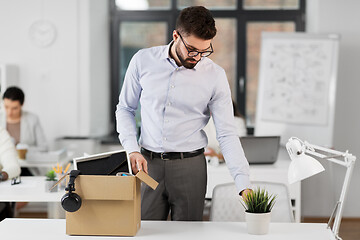 Image showing sad fired male office worker with personal stuff