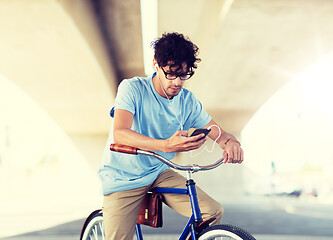 Image showing man with smartphone and earphones on bicycle