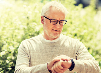 Image showing senior man checking time on his wristwatch