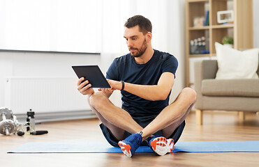 Image showing man with tablet computer on exercise mat at home