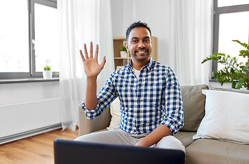 Image showing indian male blogger waving hand at home