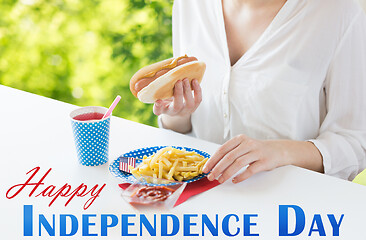 Image showing close up of woman eating hotdog and french fries