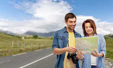 Image showing happy couple of tourists with map and camera