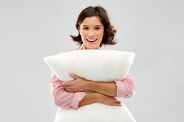 Image showing happy young woman in pajama hugging pillow