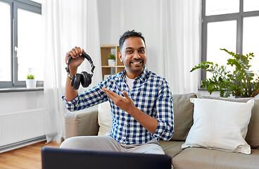 Image showing male blogger with headphones videoblogging at home