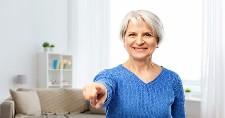 Image showing happy senior woman pointing finger to you at home