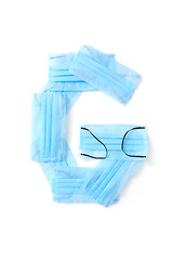 Image showing Letter G made from protective medical masks on a white background.