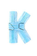 Image showing Letter K made from protective medical masks on a white background.