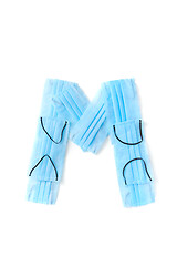 Image showing Letter M made from protective medical masks on a white background.