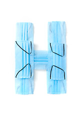 Image showing Letter H made from protective medical masks on a white background.